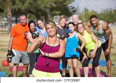 Boot camp fitness instructor with group and thumbs up - Powered by Shutterstock