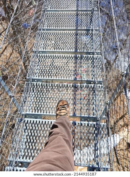boot of man on
the suspension bridge in
winter