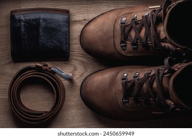 Boots, belt, wallet on wood table stil life