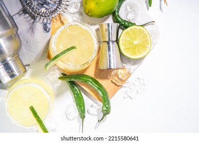 Boozy Classic Tequila  Margarita Refreshing Alcoholic Sweet And Sour Cocktail, With Lime,  Tequila, Green Chili Pepper. With Bar Accessories, Shaker, Ice Cubes On White Table