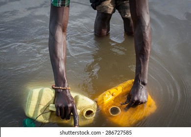 Bor, South Sudan - February 25, 2014: A South Sudanese man collects water from a river