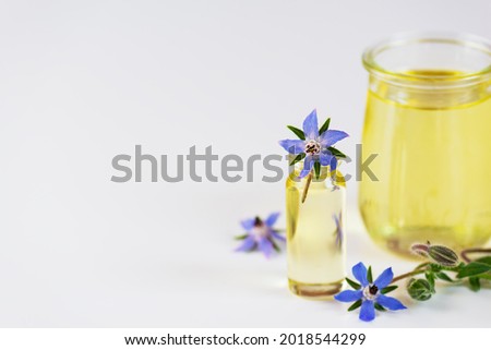 Borage oil in glass jars on a white background. Horizontal orientation, copy space.