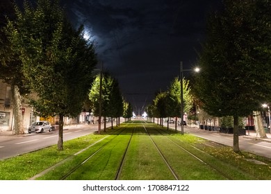 Bordeaux, France - 23th September, 2018: Public Transport Electric Tram Tracks Passing Through Tree Lined Streets In The City Of Bordeaux, Quite Empty Streets At Night.