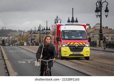 BORDEAUX, FRANCE - FEBRUARY 20, 2022: Blurred Cyclist Biking In Front Of A VSAV, A First Aid And Emergency Intervention Ambulance Vehicle From Pompiers, The French Firefighters. 

