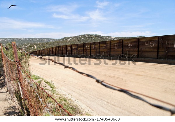 Border between the United States and Mexico, near Campo,
California and Tecate, Mexico. Barbed wire and a rusty metal wall
with numbers 44 and up. As seen from the American side of the
border. 