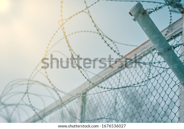 Border fence with barbed wire.\
Closing for quarantine. Maximum Security Detention\
Facility.