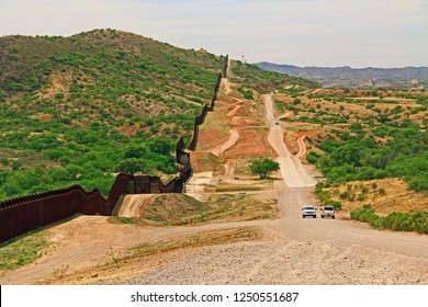 Border Fence Beside A Road Near Nogales, Arizona Separating The United States From Mexico With Border Patrol Vehicle. 