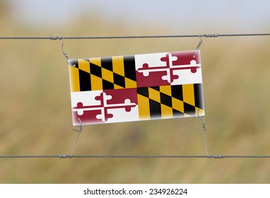 Border Fence - Old Plastic Sign With A Flag - Maryland