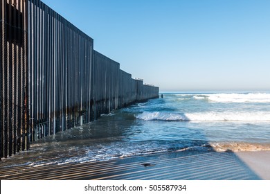 Border Field State Park beach in San Diego, California with the international border wall separating the United States from Tijuana, Mexico.