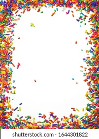 A Border Frame Of Rainbow Sprinkles Over White Background