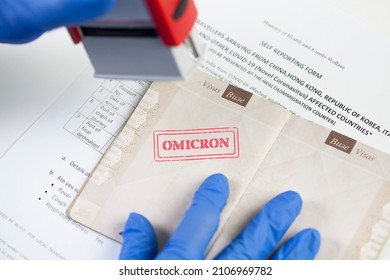 Border security officer wearing blue protective gloves stamping OMICRON onto document,airport border customs health and safety security check,safety measures due to outbreak of new Coronavirus variant - Shutterstock ID 2106969782