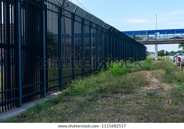 Border wall between Texas US Mexico\
border underneath the international bridge port of\
entry