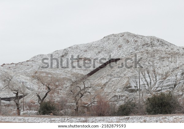 Border\
wall covered in snow in the mountains in El\
Paso.