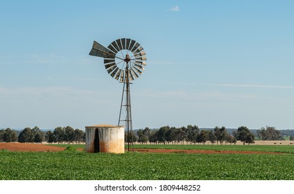 Bore Water Windmill Pump With Tank In Rural Australia, Energy Saving Equipment For Watering And Feeding Livestock And Crops.