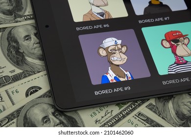 BORED APE NFT Digital Art Collection Seen On Tablet Screen Placed On 100 Dollar Bills. Bored Ape Yacht Club (or BAYC) Is The Most Expensive NFTs. Stafford, United Kingdom, January 5, 2022.