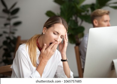 Bored businesswoman yawning at workplace feeling no motivation or lack of sleep tired of boring office routine, exhausted restless employee gaping suffering from chronic fatigue or overwork concept