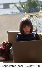 Bored Child Hypnotized By Computer For Lockdown Homeschool Learning While Pandemic Class Closure Or Kid Screen Overdose, City Background