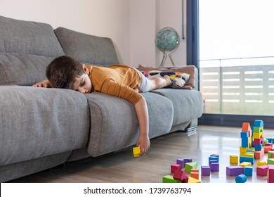 Bored Child Playing With Blocks At Home