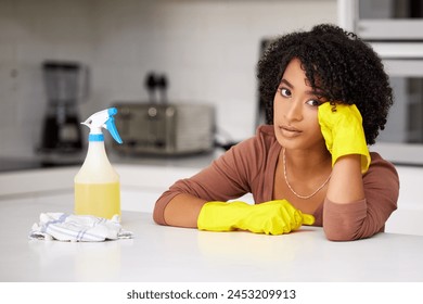 Bored, cleaning and portrait of black woman in kitchen of home for housekeeping chores. Cloth, gloves and spray with exhausted or tired person at counter in apartment for housework or responsibility - Powered by Shutterstock