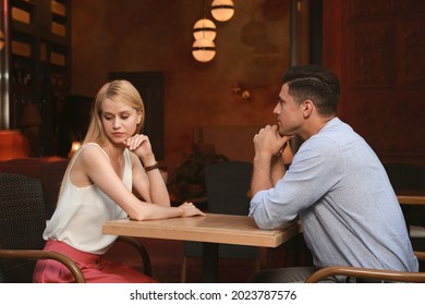 Bored couple having unsuccessful date in cafe