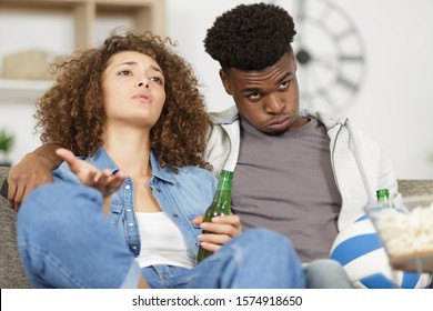 Bored Couple Watching Football Match On Tv