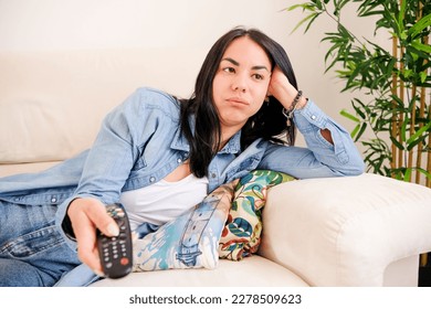 Bored and disengaged woman, searching for something to capture her attention on television at home - Shutterstock ID 2278509623
