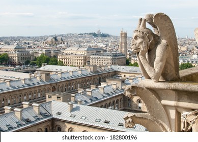 A bored gargoyle sits on top of Notre Dame surveying the Parisian cityscape below.