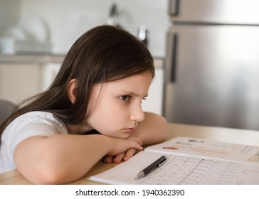 Bored Girl Child At Home Schooling. The Girl Studies At Home, The Concept Of Home Education And Preparation For The 1st Grade Of School. Close-up