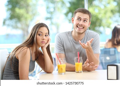 Bored girl listening a bad conversation from a friend or partner in a coffee shop or hotel on the beach - Powered by Shutterstock