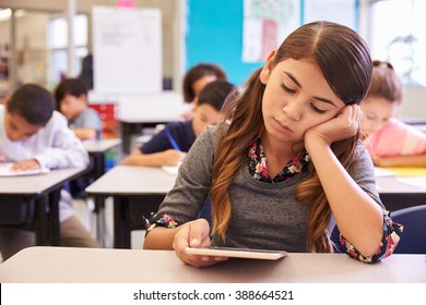 Bored Girl Reading Tablet In Elementary School Class