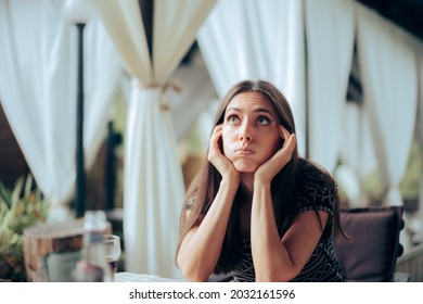 Bored Girlfriend Waiting For Her Date In A Restaurant. Unhappy Young Woman Sitting At An Anniversary Party Event
