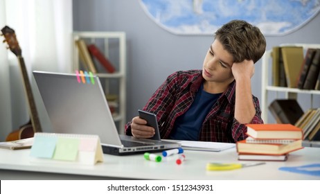 Bored guy scrolling apps on phone, distracted from homework, procrastination