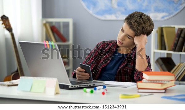 Bored guy scrolling apps on phone,
distracted from homework,
procrastination