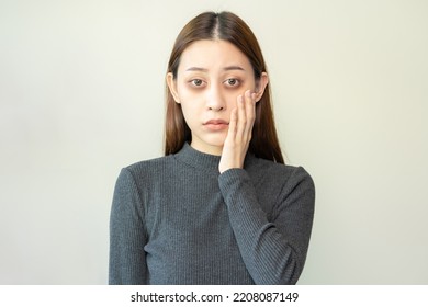 Bored, insomnia asian young woman, girl looking at camera, hand touching under eyes with problem of black circles or panda puffy, swollen and wrinkle on face. Sleepless, sleepy healthcare person. - Shutterstock ID 2208087149