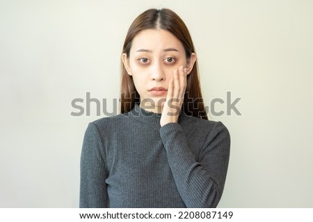 Bored, insomnia asian young woman, girl looking at camera, hand touching under eyes with problem of black circles or panda puffy, swollen and wrinkle on face. Sleepless, sleepy healthcare person.
