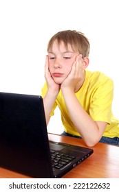 Bored Kid At The Desk With Laptop Isolated On The White Background