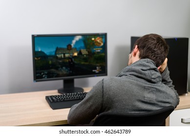 Bored Male Gamer Playing Video Games On Computer - Stock Photo