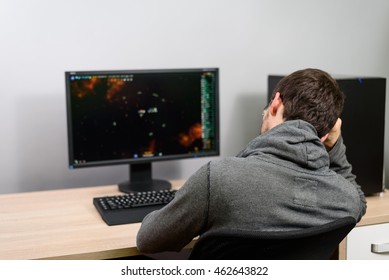 Bored Male Gamer Playing Video Games On Computer - Stock Photo