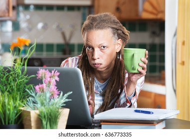 Bored Mature Student With Notebook, Pen And Laptop Computer Indoors