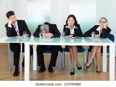 Bored panel of professional judges or corporate interviewers lounging around on a table napping as they wait for something to happen