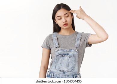 Bored Reluctant Asian Dark-haired Girl Cannot Stand Boring Talk Close Eyes Hold Finger Pistol Shoot Herself Commit Suicide Boredom Uninteresting Event Sighing Exhausted Reluctant White Background