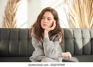 bored and sad woman sitting on couch with no mood and prop up head with hand - Shutterstock ID 2232747949