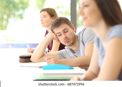 Bored Student Distracted During A Class At Classroom With Classmates In The Background