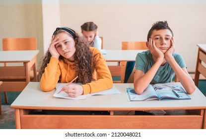 Bored students sitting at school desk during the class.	 - Powered by Shutterstock