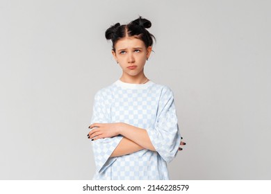 Bored Teen Girl Looking Aside With Sad, Gloomy And Unamused Expression, Standing Upset And Moody In Trendy T Shirt Over Light Grey Background