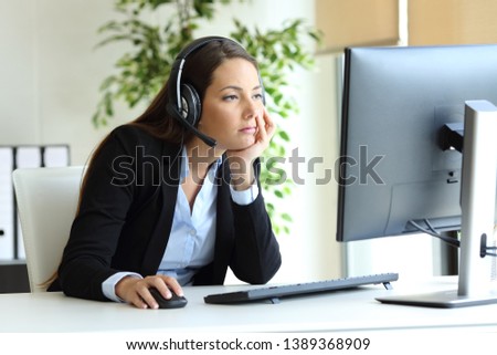 Bored telemarketer working checking desktop computer at office