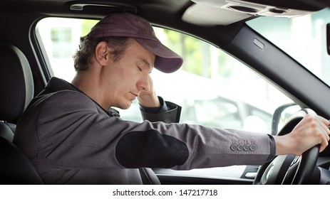 Bored, tired man sleeping at the wheel of his car