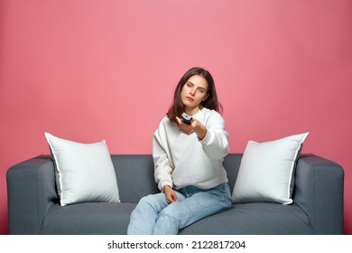 Bored Woman Switching Channels With Remote Controller, Sitting On Sofa, Watching TV Shows. Procrastination Concept 