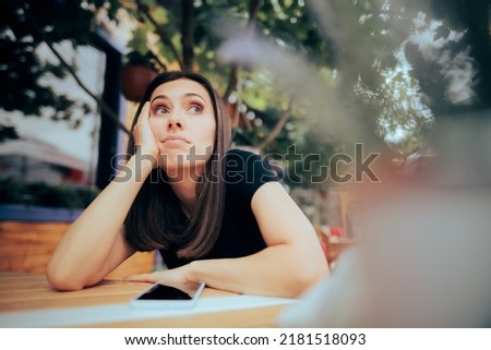 

Bored Woman Waiting a Phone Call in a Restaurant. Lonely woman feeling depressed and disappointed after a cellphone breakup

