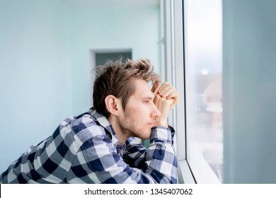 Bored Young Man Feeling Sad And Standing In Front Of The Mirror 